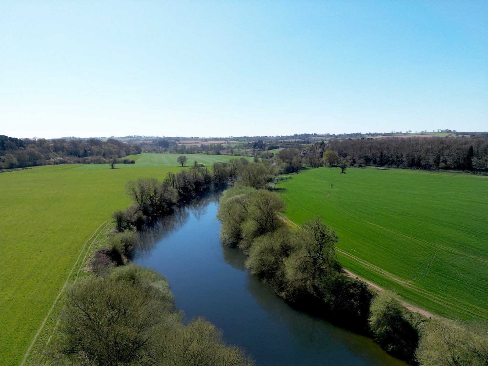 The River Severn curving between green meadows at Quatford, seen from above on a clear spring day